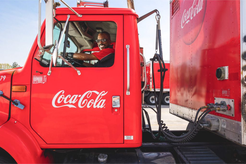 Driver smiling from the seat of a Coca Cola truck