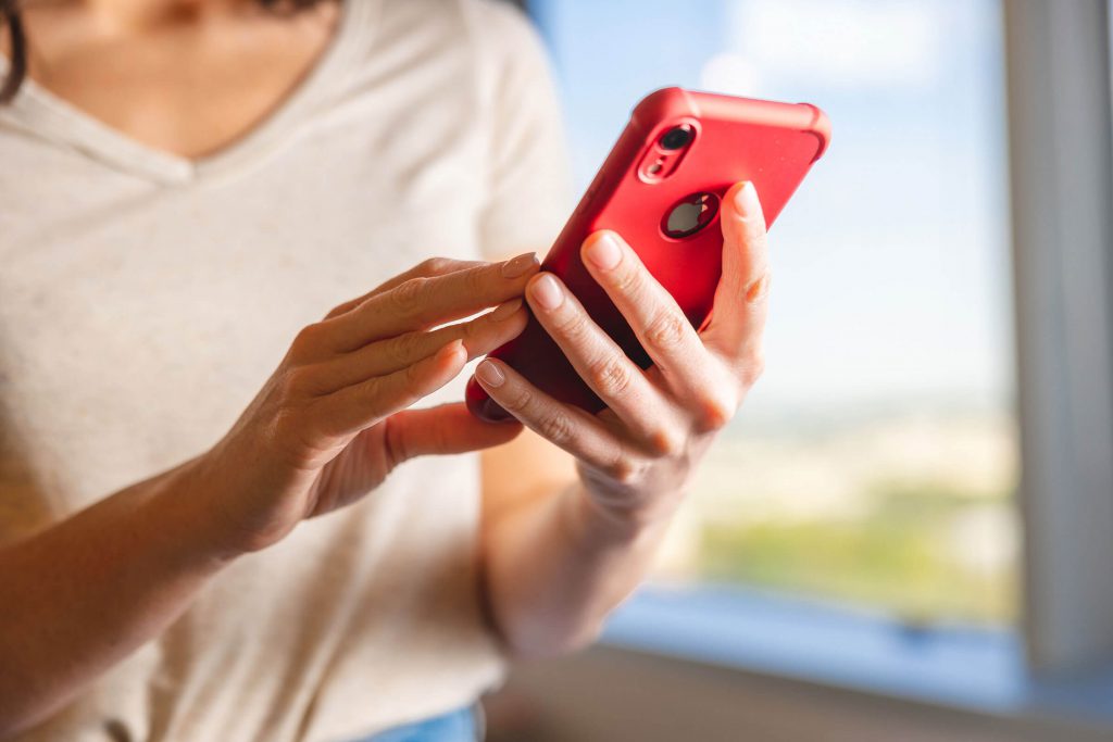 Woman holding a red mobile phone